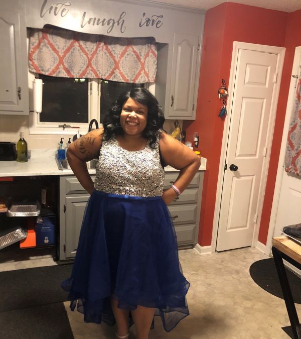 Stephanie Smith stands in her kitchen dressed in evening wear
