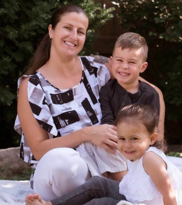 A beautiful family portrait of Amy Almas outside with her two super-smiley children