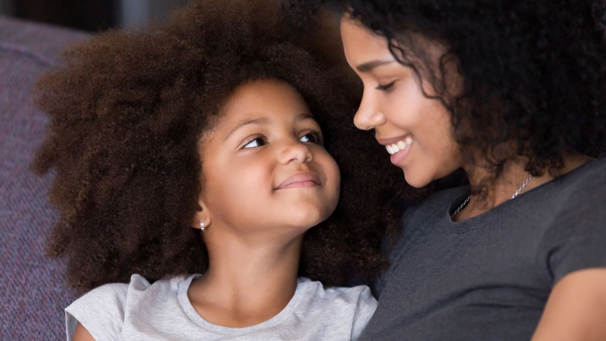A Black girl looks adoringly at her mom
