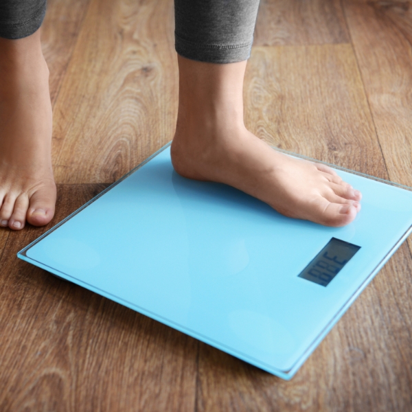 Woman stepping on an at-home scale