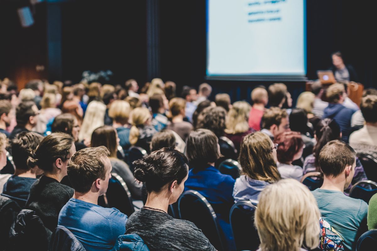 Crowd of people looking at a presentation.