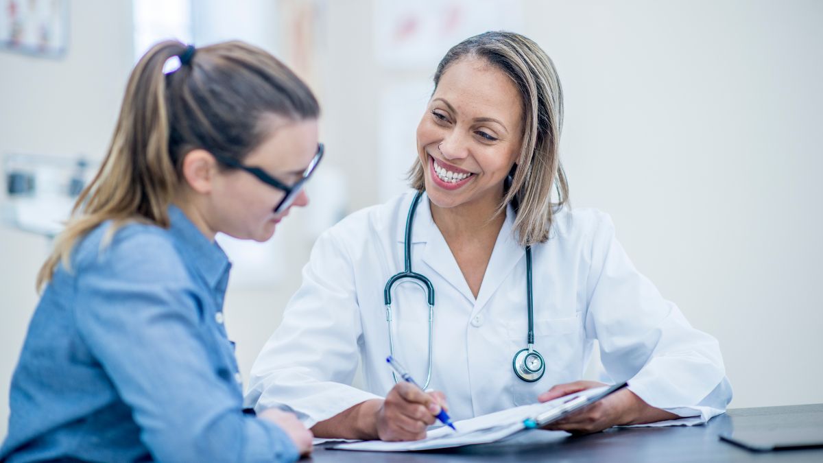 Doctor and patient conversing in a doctor's office.