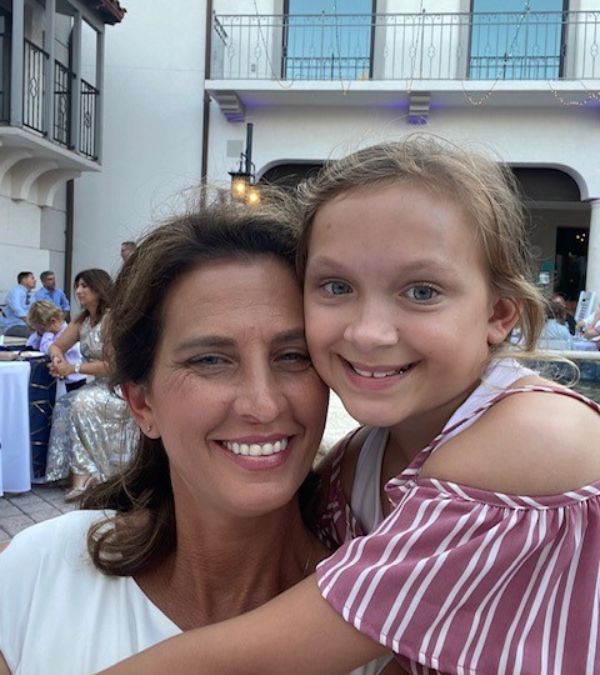 Shiloh Chism and her daughter smile hugely at an outdoor plaza