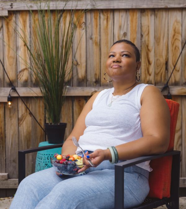 Kelly Choy-Wilson sits in her patio enjoying her fruit salad.