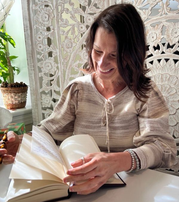 Adriana Lecuona happily writes in a journal at her desk.