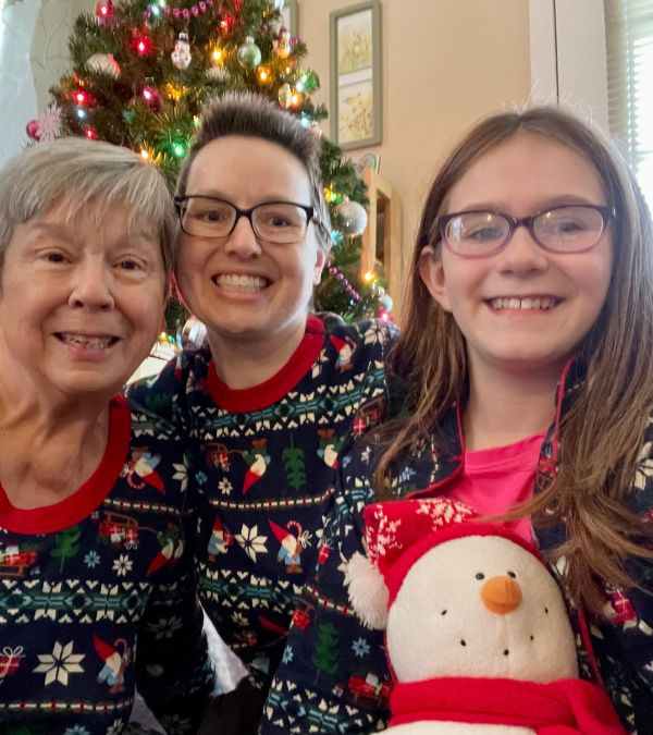 Jenni Hetzel-Gayner, her mom, and her niece wear matching pajamas in front of the Christmas tree.