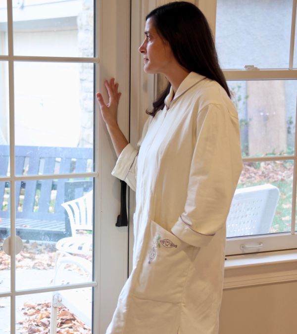 A "Comforting Wrap" designed by Marlene Lally looks cozy on a woman who looks out her patio door.