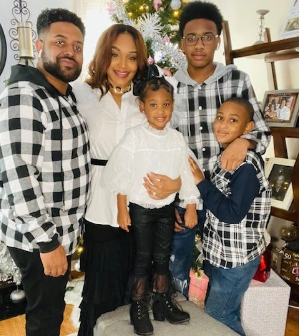 Monisha Parker's family looks stylish in front of the Christmas tree all dressed in black and white.