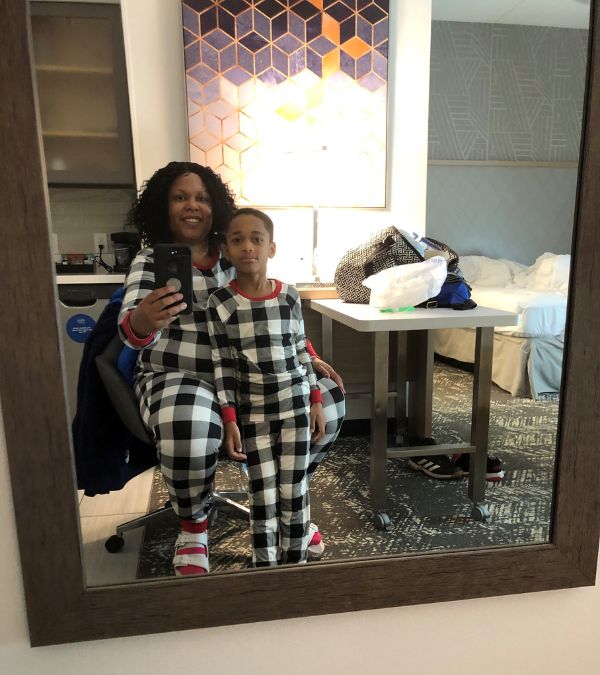 Stephanie Smith and her son wear matching PJs as they enjoy a hotel room.