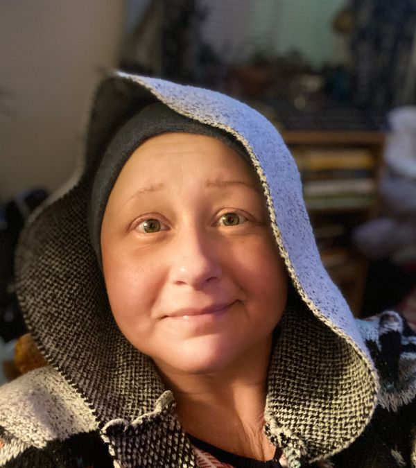 Jenna Antonelli, looking thoughtful, wears a soft, ethnic hooded jacket.
