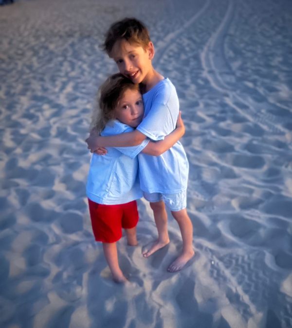 Shannon Gottesman's two young boys hug each other on the beach.