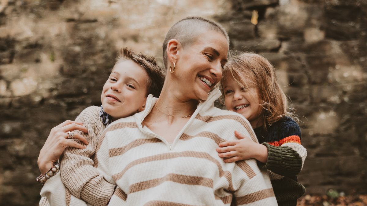 Shannon Gottesman is surrounded on either side of her by her two young boys who wrap her up with smiles and hugs.