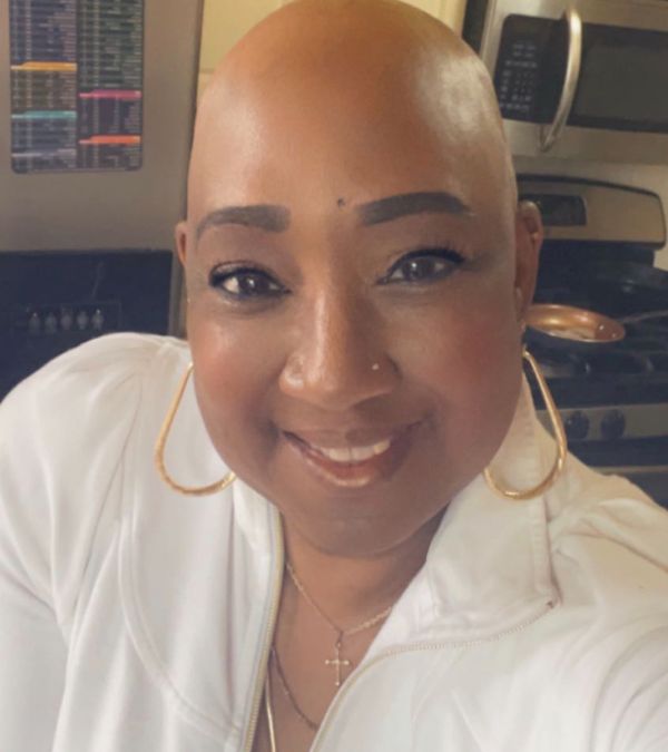 Stephani St. Cyr embraces a bald look with a bold smile - and hoop earrings.