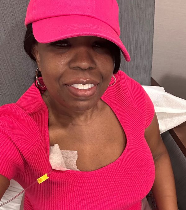 La-Trenda Ross wears a vibrant pink heat as she gets her chemo infusion via the port on her chest.