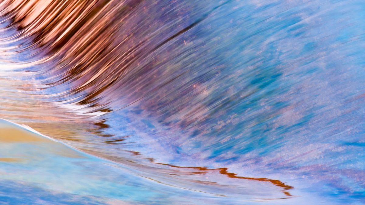 A close-up of water rushing over a rock in a river.
