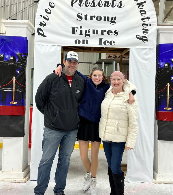 Klara Hartfiel's daughter is flanked on either side by her parents on the ice staking rink during an event.