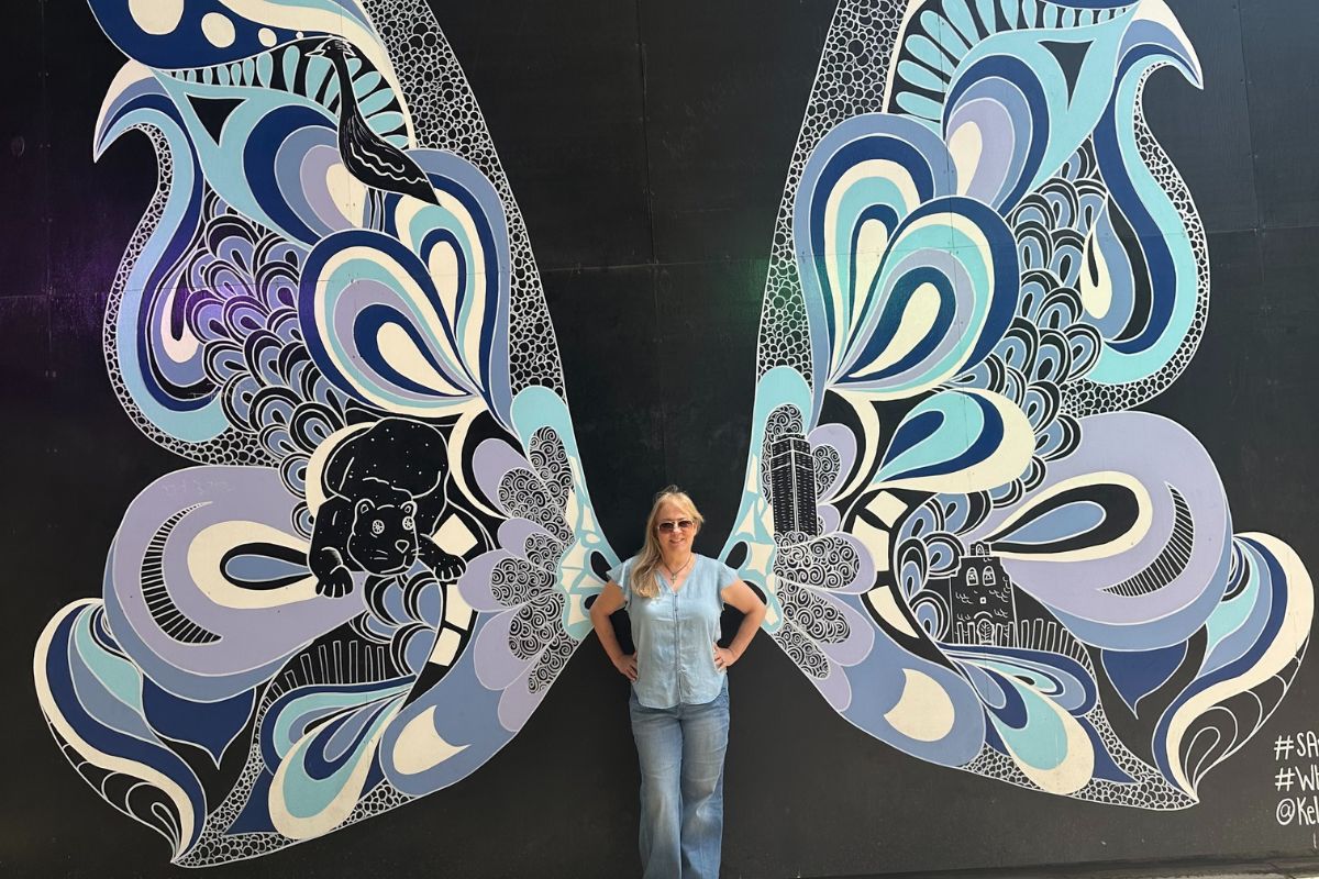 Celebrating 5 years since she discovered her breast cancer lump, Maria Lleonart turns 60 and poses between enormous butterfly wings.