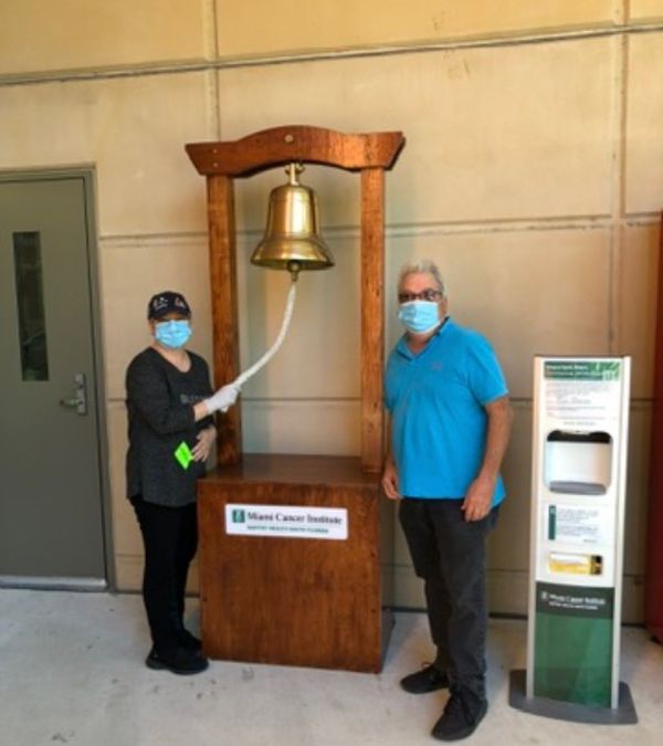 Maria Lleonart finishes radiation and rings a big bell, accompanied by her husband.