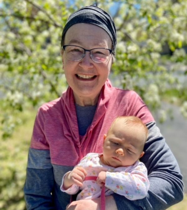 Maura Roby holds her just-born granddaughter on a sunny day.