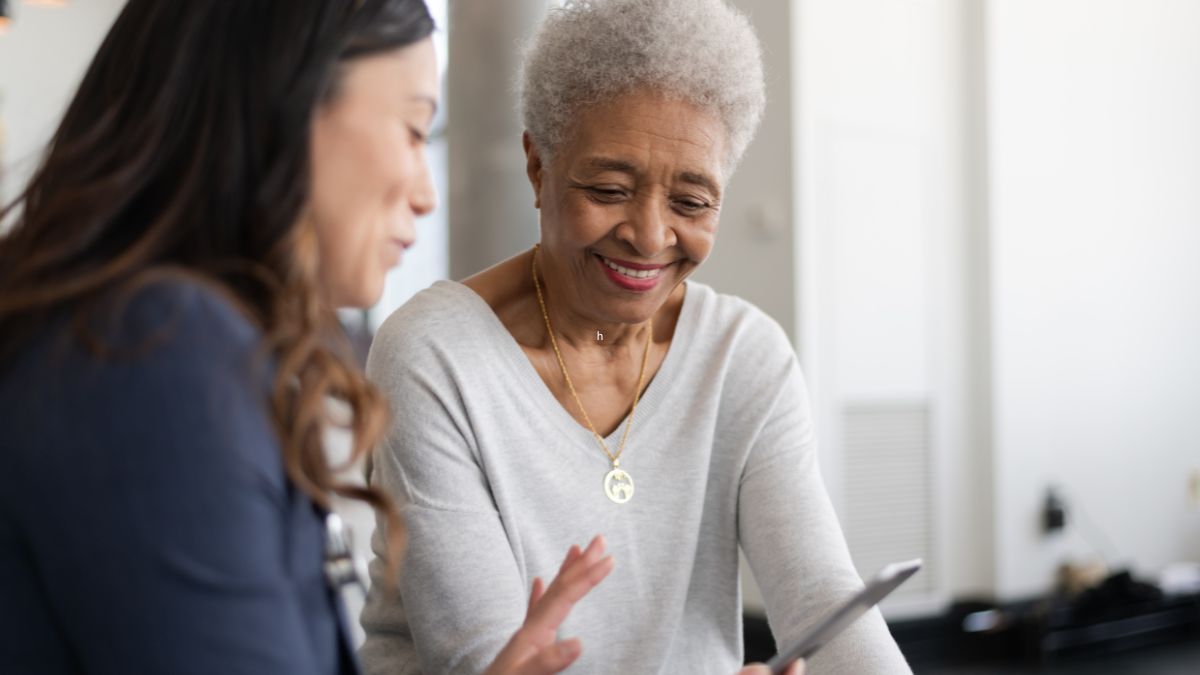 An older Black woman consults with her doctor about the steps she can take before her treatment.
