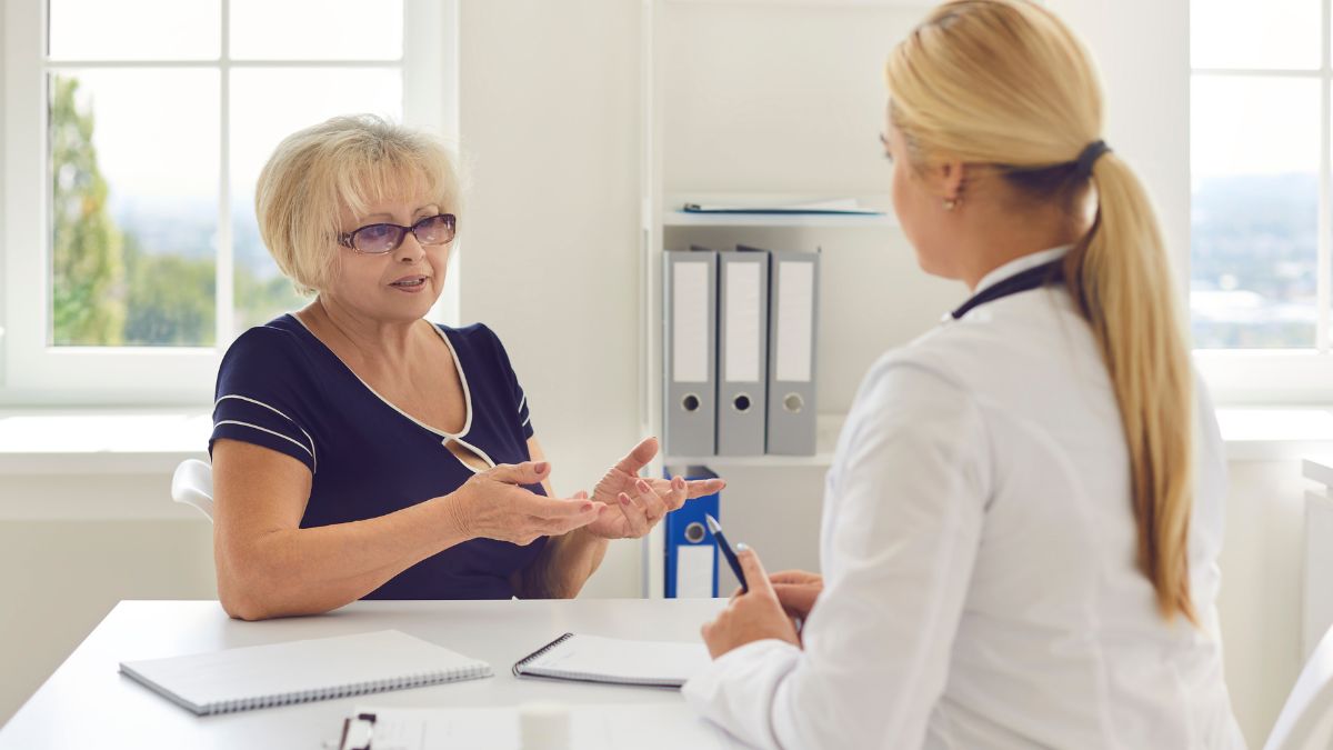 A woman calmly asks her doctor questions as they meet in the doctor's office.