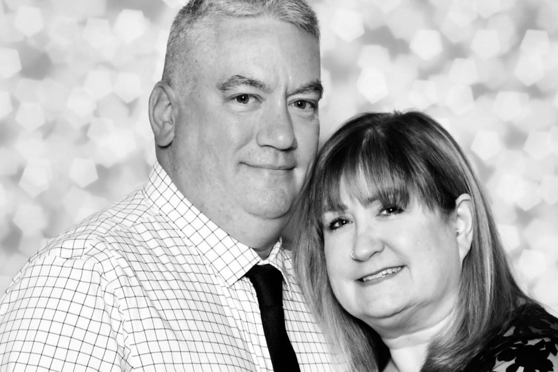 Amy Russell-Parliman and her husband lean in close to each other in this black-and-white portrait celebrating their relationship.