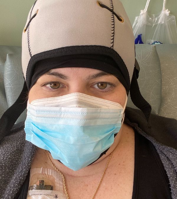 Jordana Shief Needle wears a cold cap and a face mask as she gets chemotherapy.