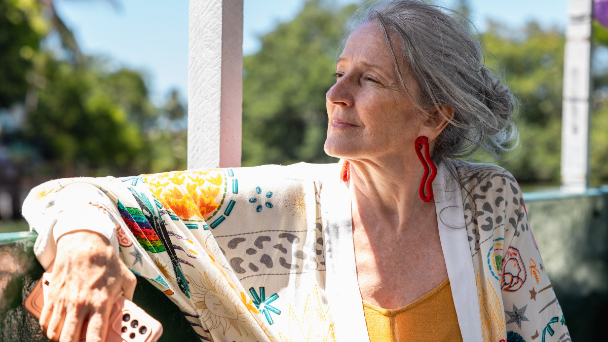 Woman with grey hair looks out a window
