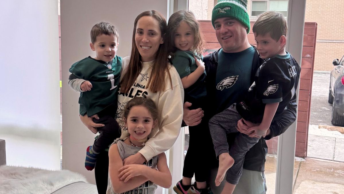 Marisa Berman, her husband, and four young children huddle together, wearing Eagles wear.
