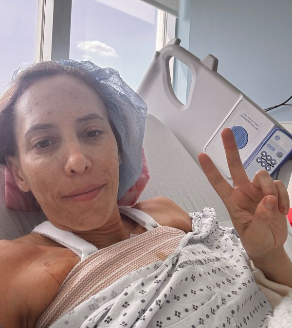 Marisa Berman signs "peace" from her hospital bed after her double mastectomy.