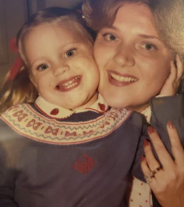 A vintage photo of Charlotte Safrit as a little girl in a fairisle sweater, with her mom hugging her close.