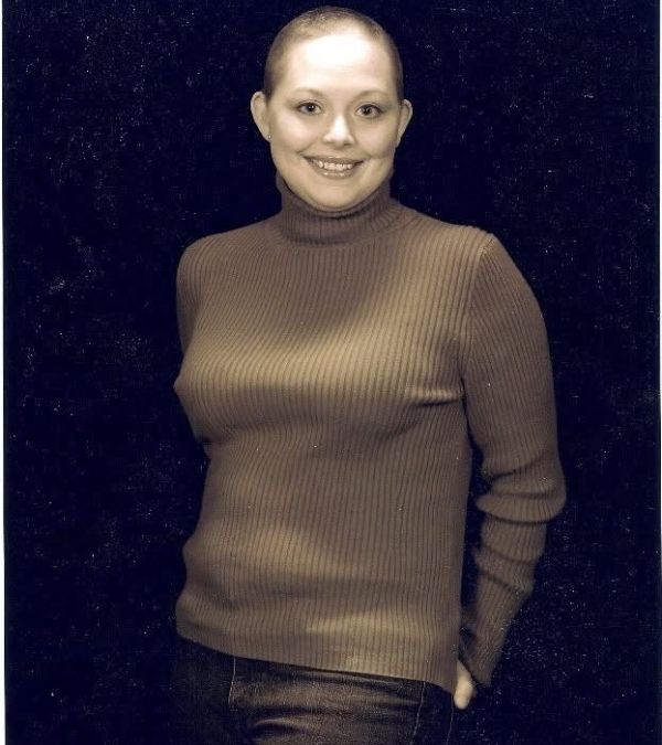 A young Courtney Bugler has her hair shorn, but her smile remains bright.