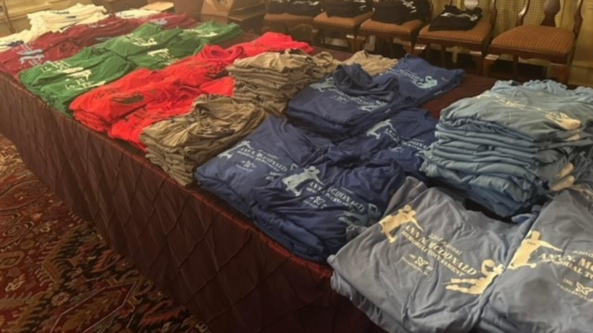 The table with the different colored team shirts on display