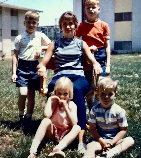 Old photo of a Ann sitting outside surrounded by her four young children