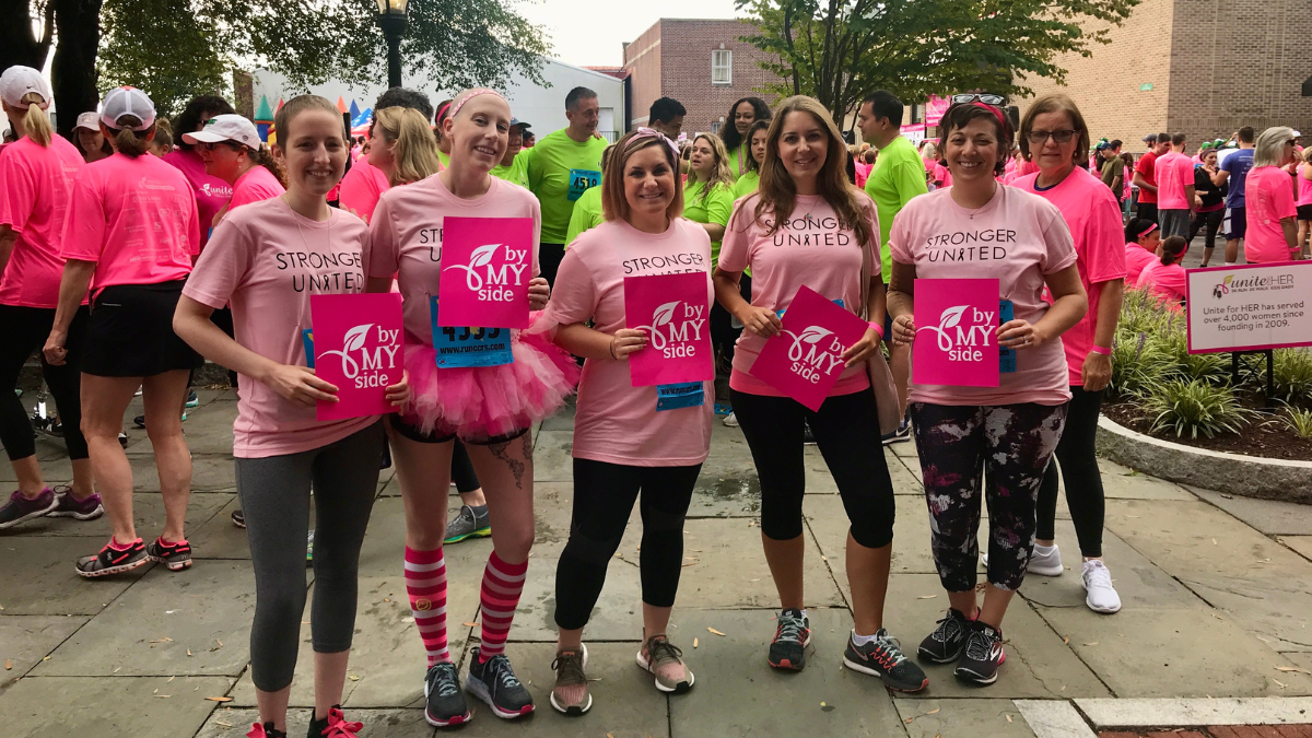 Caroline Abi-Khattar smiling in pink with other breast cancer survivors