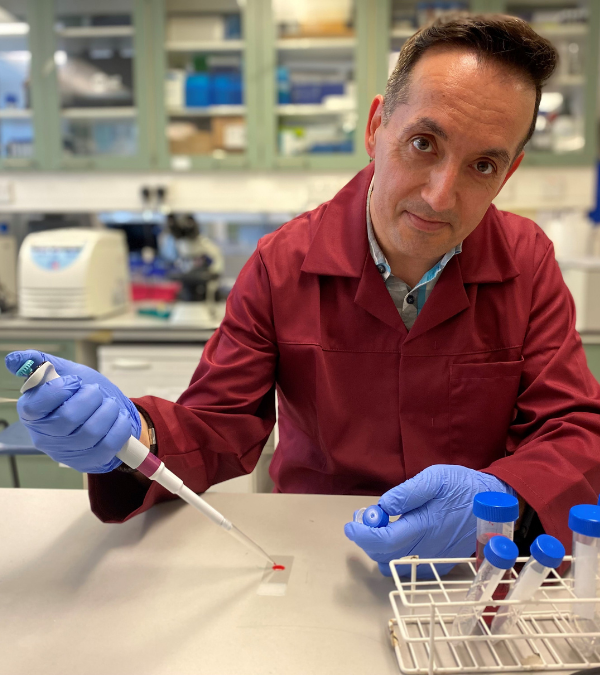 Nik Georgopoulos in the lab holding a pipette