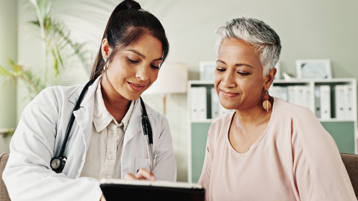 An Indian doctor showing a document to a Latina patient