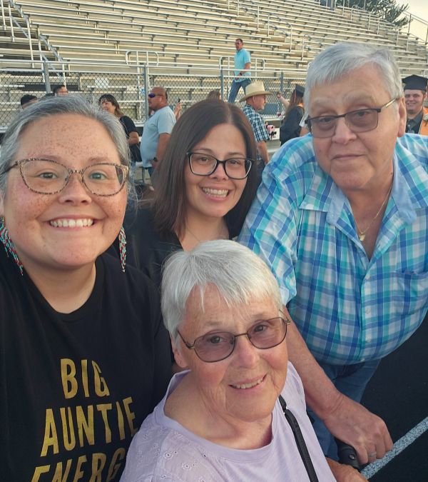 Lisa Walker attends a sporting event with her mom, dad, and sister.