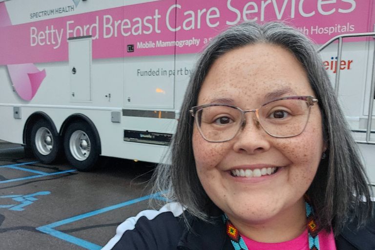 Lisa Walker stands proudly in front of the mobile mammography unit which is part of a program she led to help Native American women have greater access to care.