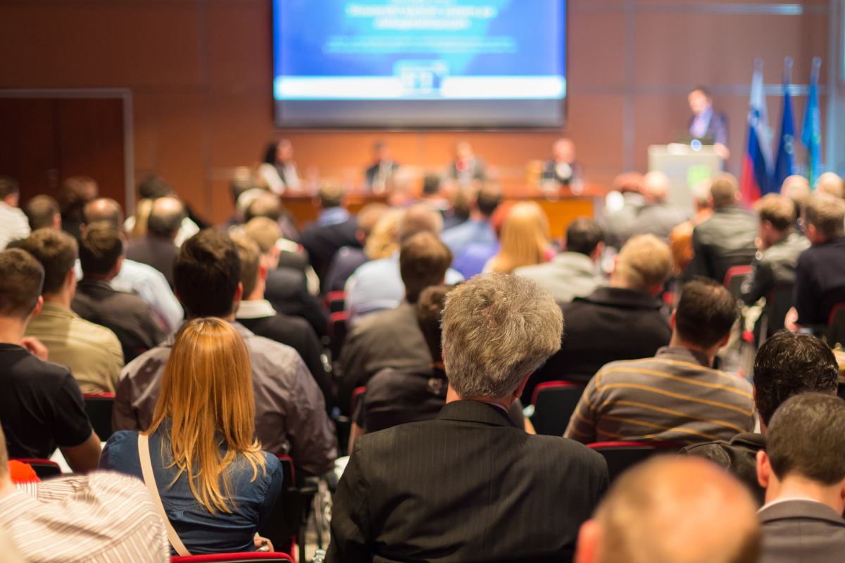 A crowd of people looking at a presentation