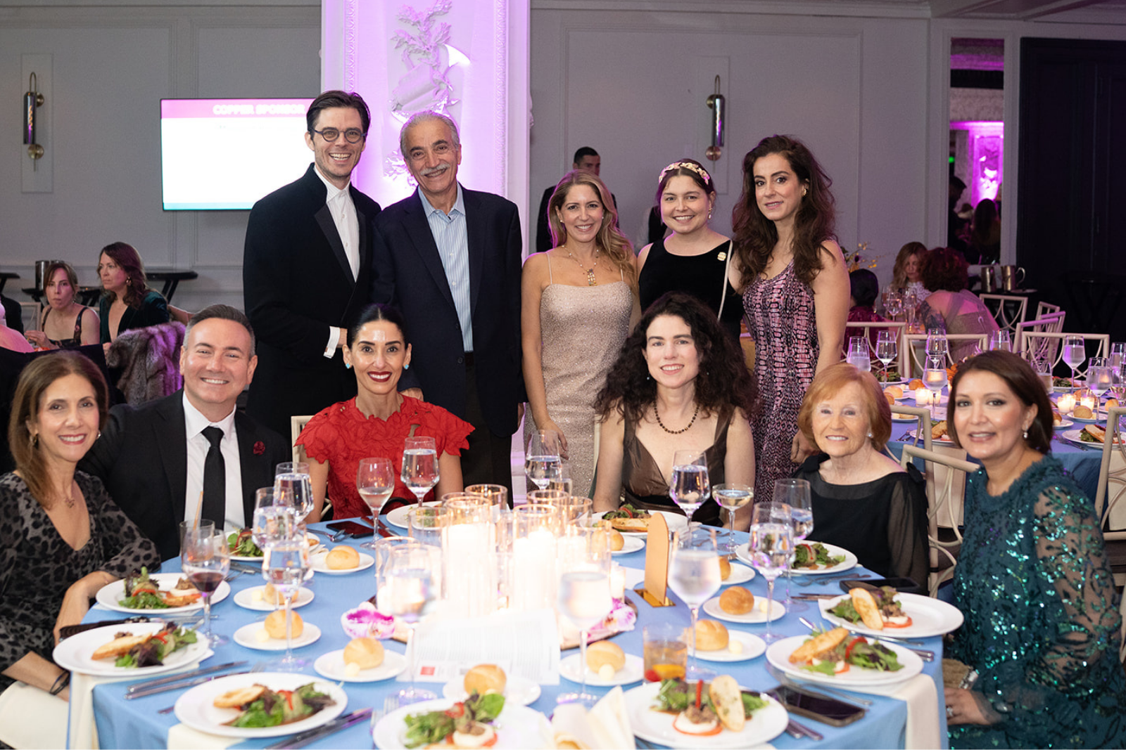 A diverse group of people smiling at their table