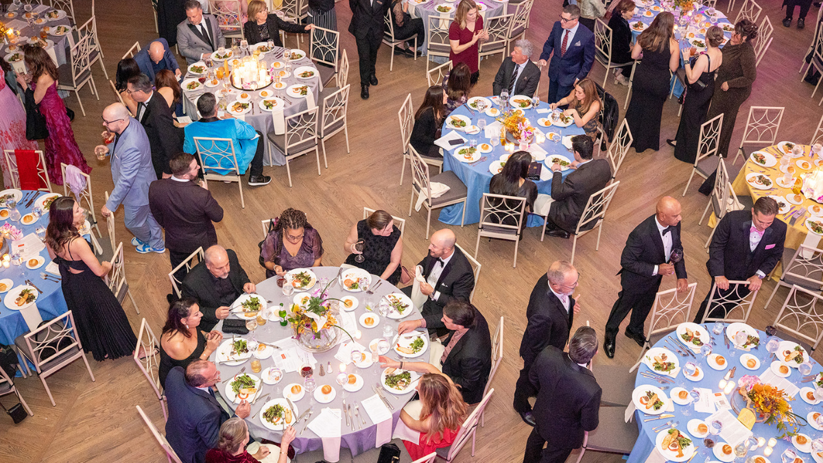Overhead view of 6 tables eating dinner at the Butterfly Ball