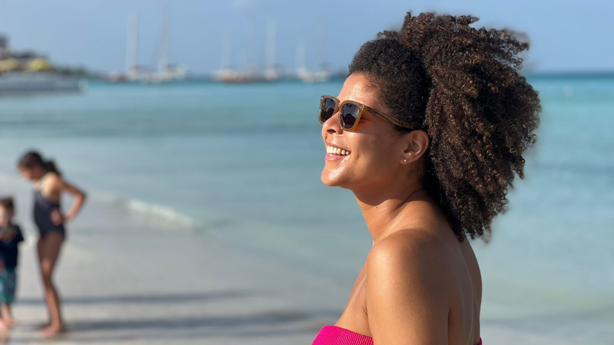 Amara Brown with her longer hair, smiling on the beach.
