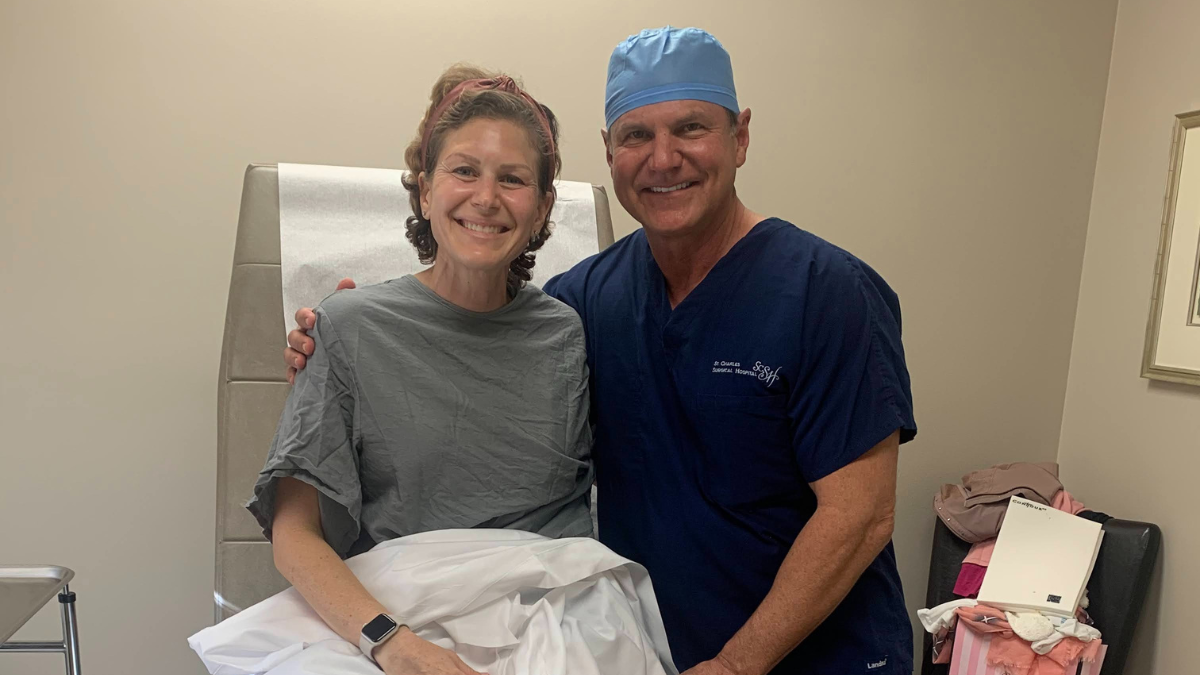 Claudia De Pasquale sitting up in a hospital gown, smiling next to her surgeon.