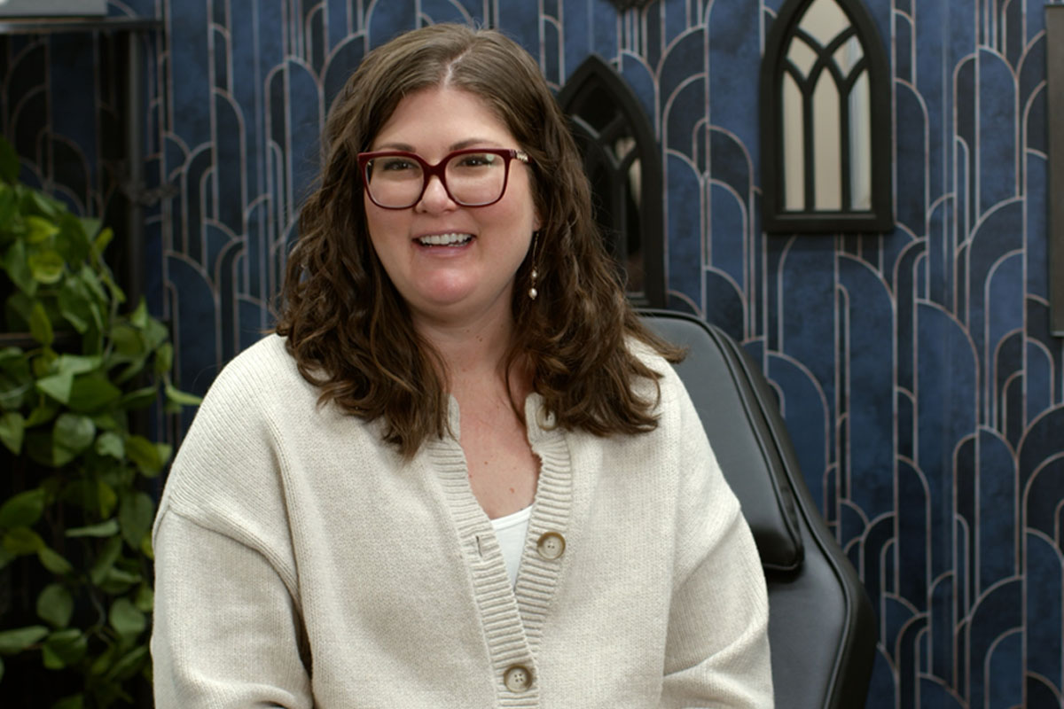 Woman with glasses sitting in a tattoo shop