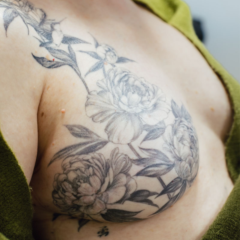 Fine line post-mastectomy tattoo of peonies with Chinese characters for "courage."