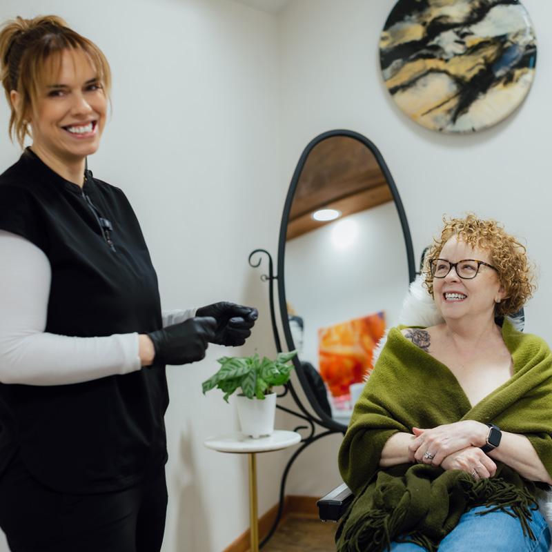 Theresa laughs with Mandy Sauler in The Sauler Institute clinic room.