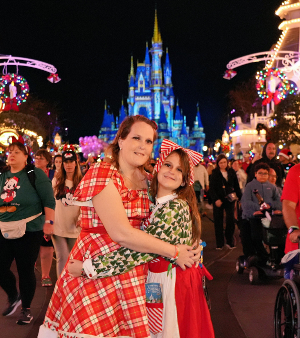 Jenny Peterson hugging her daughter in front of Cinderella's Castle in Disney World