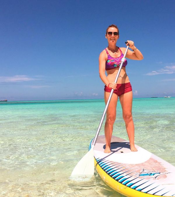 Szilvia Gogh paddleboards in beautiful tropical waters.