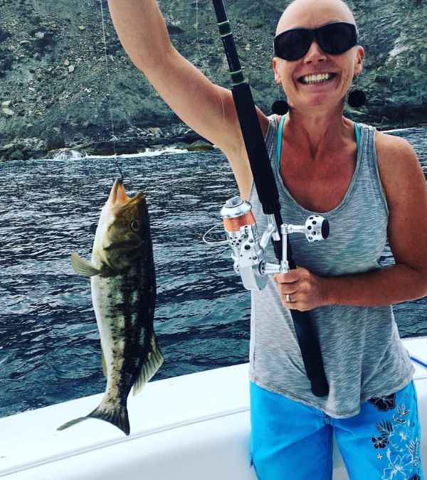 Szilvia Gogh catches a fish, and her smile is triumphant.